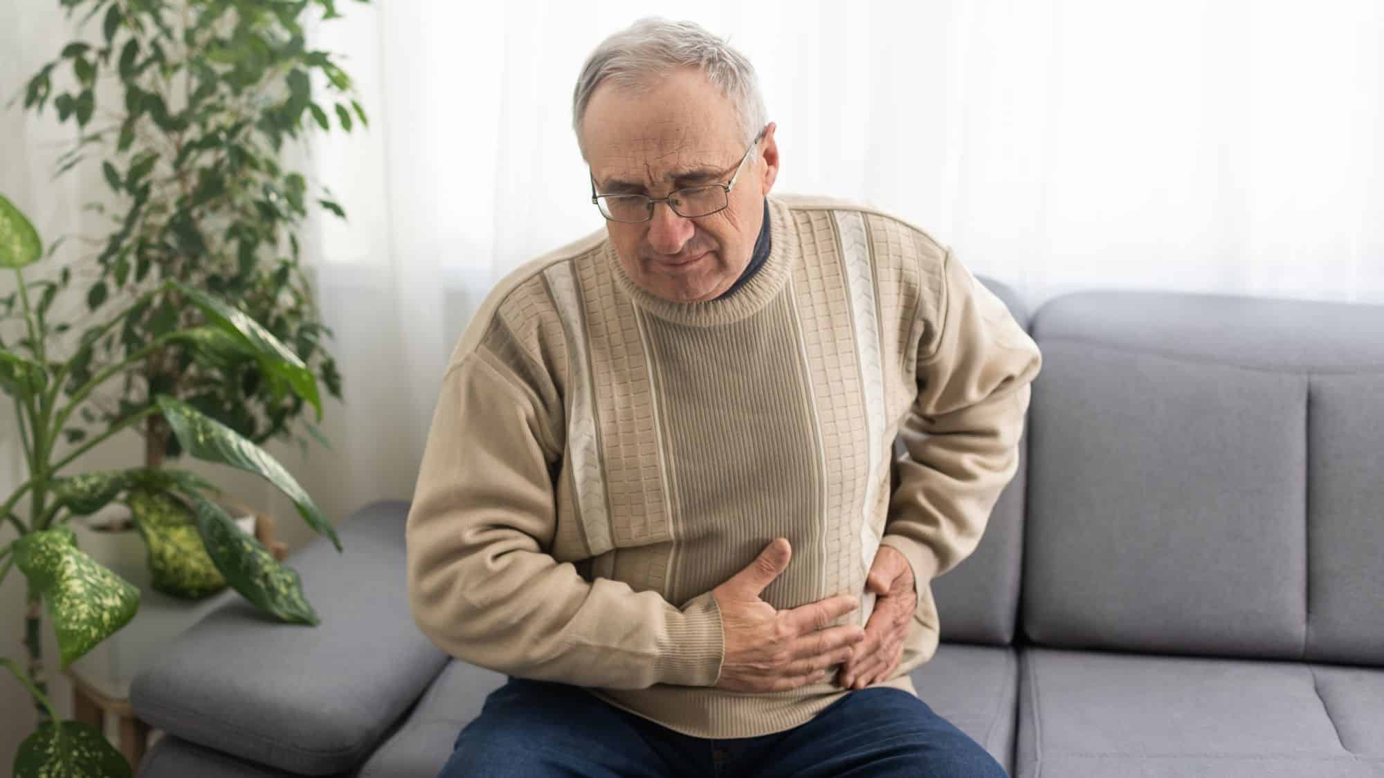 Old man clutching abdomen