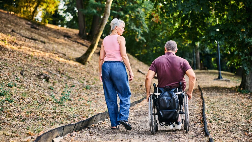 Man in wheel chair on a walk with woman