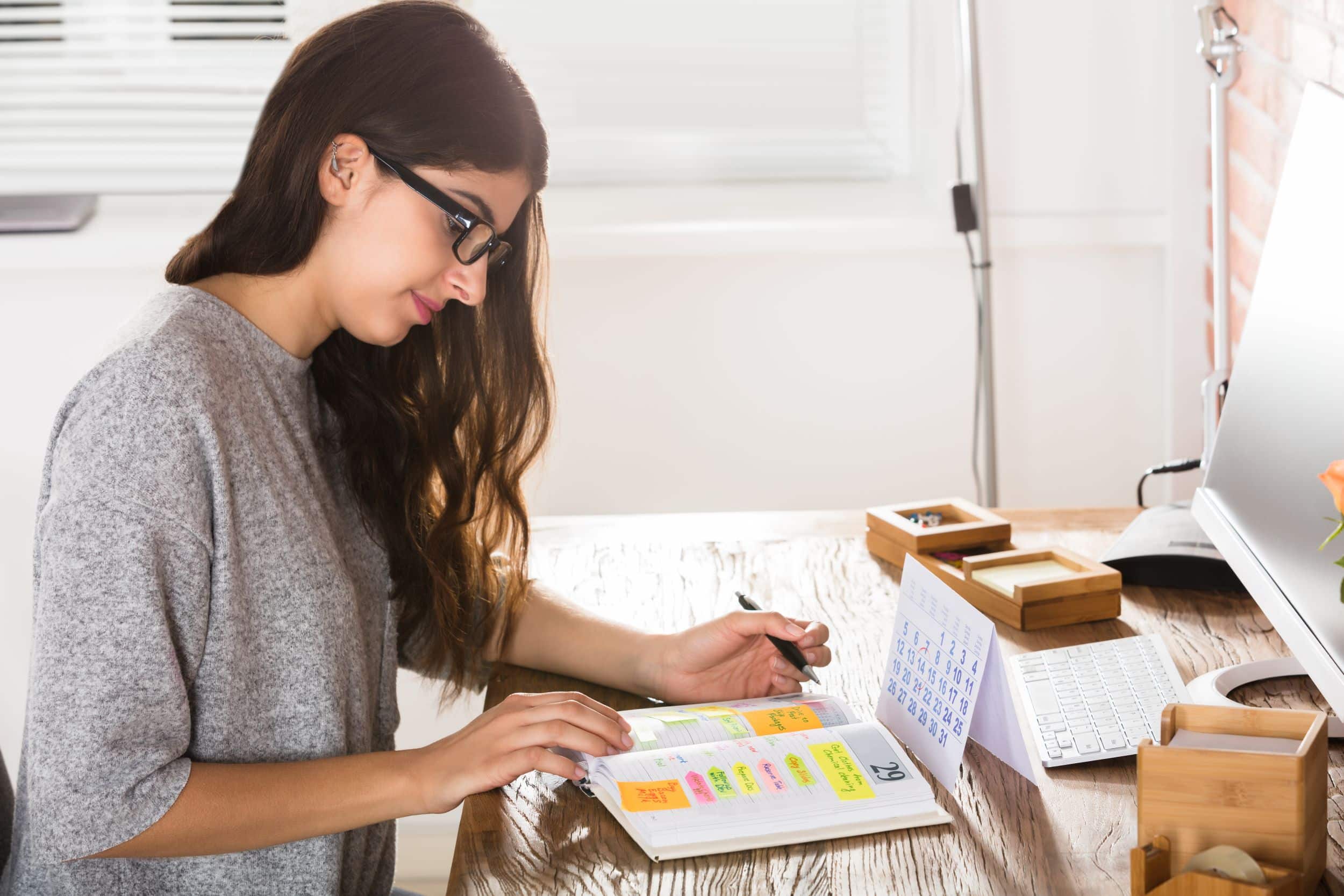 Young woman writing on calendar