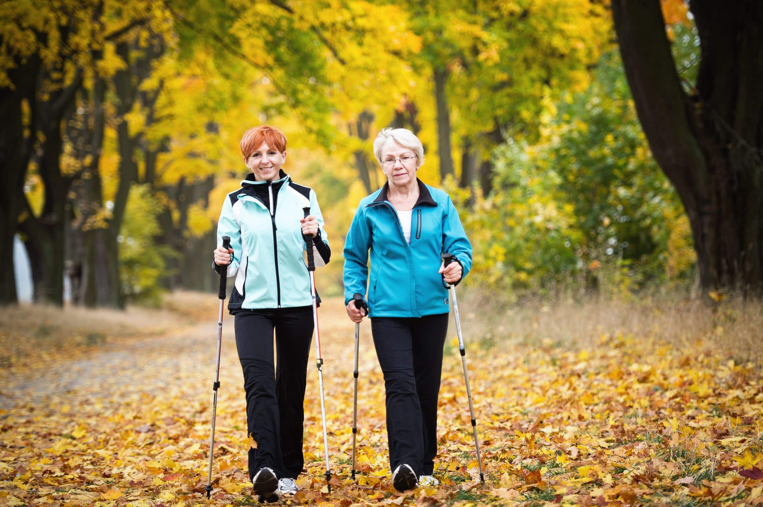 Two Women Walking Outside With Walking Sticks