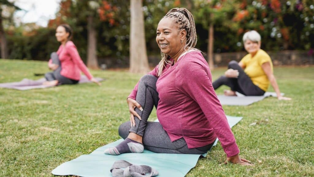 A group of women outside stretching on yoga mats