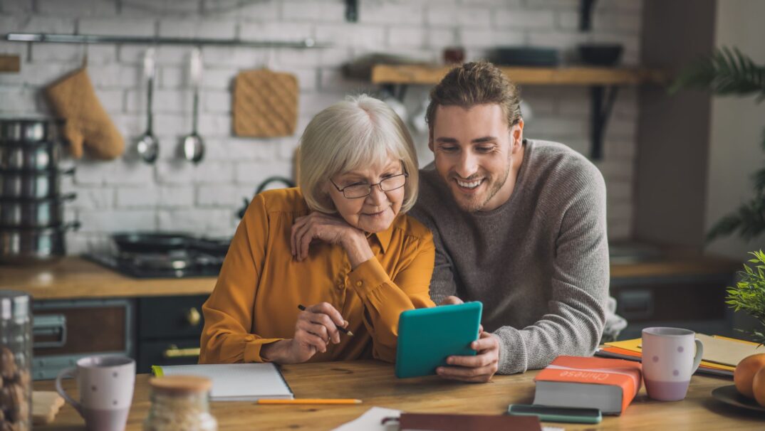 Son and mother looking at a tablet together.