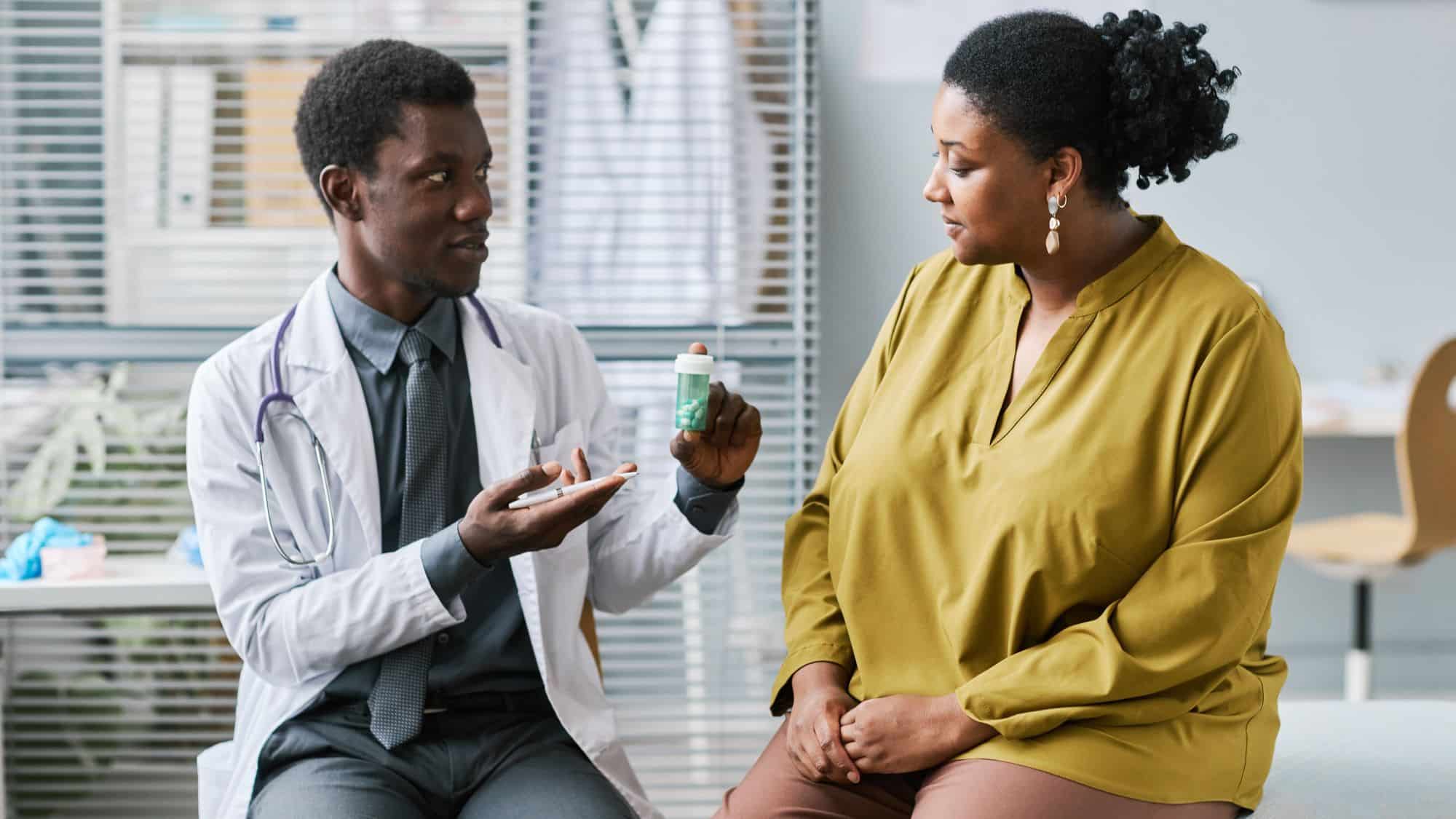 Woman sitting on exam table talking to doctor