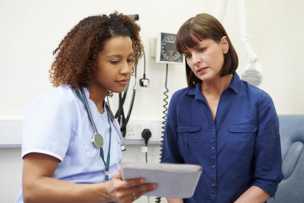 WomanInDoctorsOfficeWithNurse.