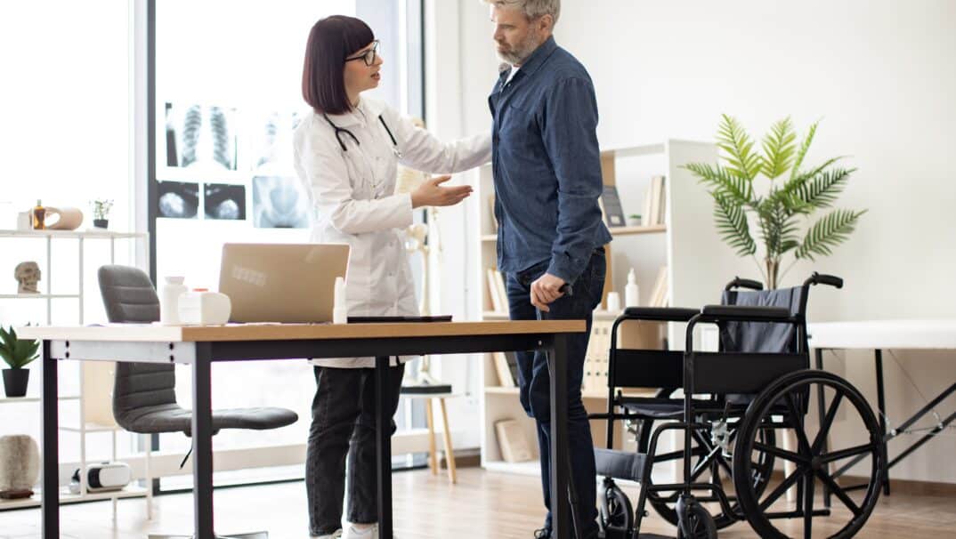 Man discussing mobility aids with doctor