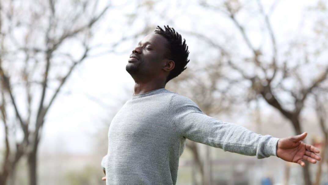 Man standing outside with his arms outstretched