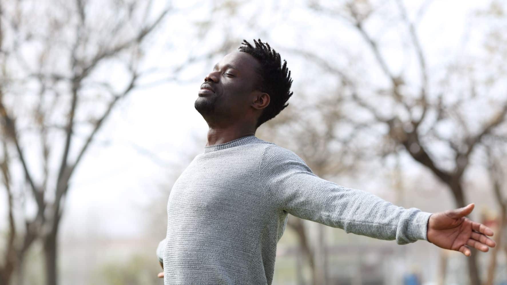 Man standing outside with his arms outstretched