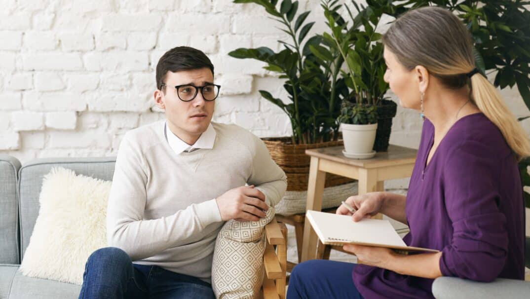 Young white man speaking to a woman neuropsychologist