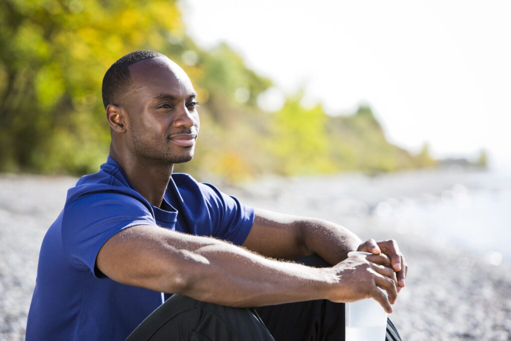 serious but hopeful young man sits looking into the distance