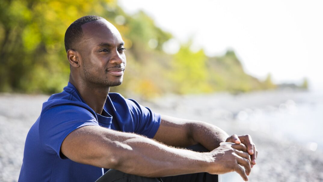 serious but hopeful young man sits looking into the distance