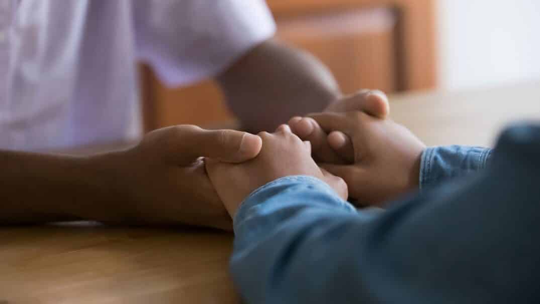 Two people holding hands over a table