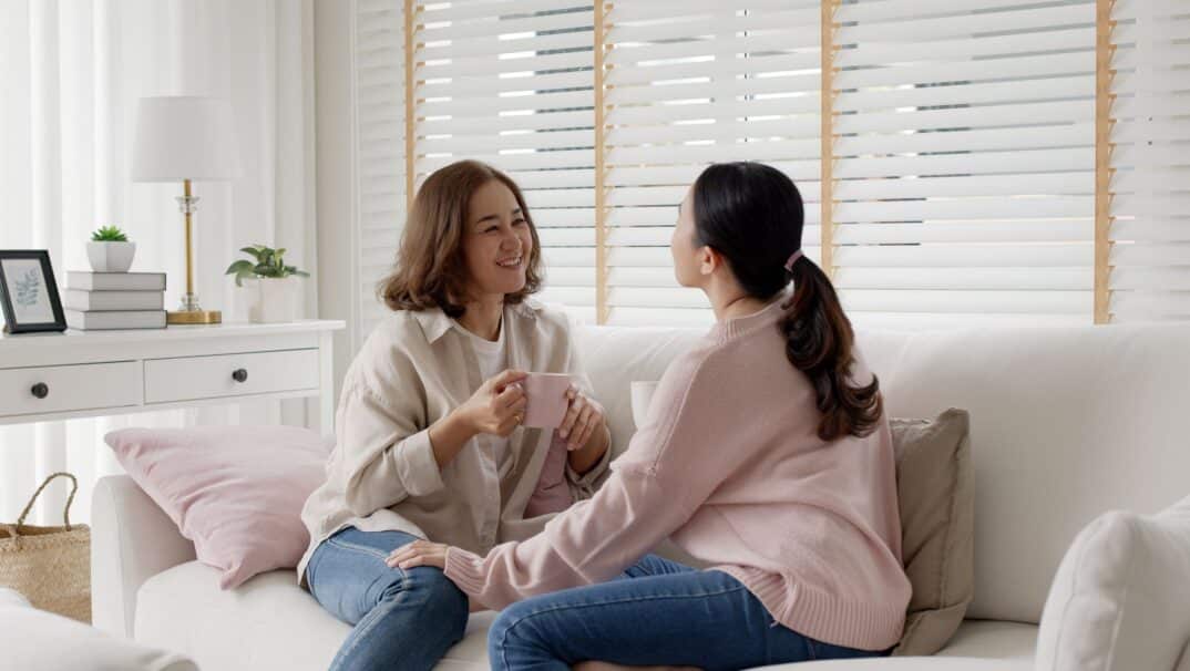 Two women talking on a couch